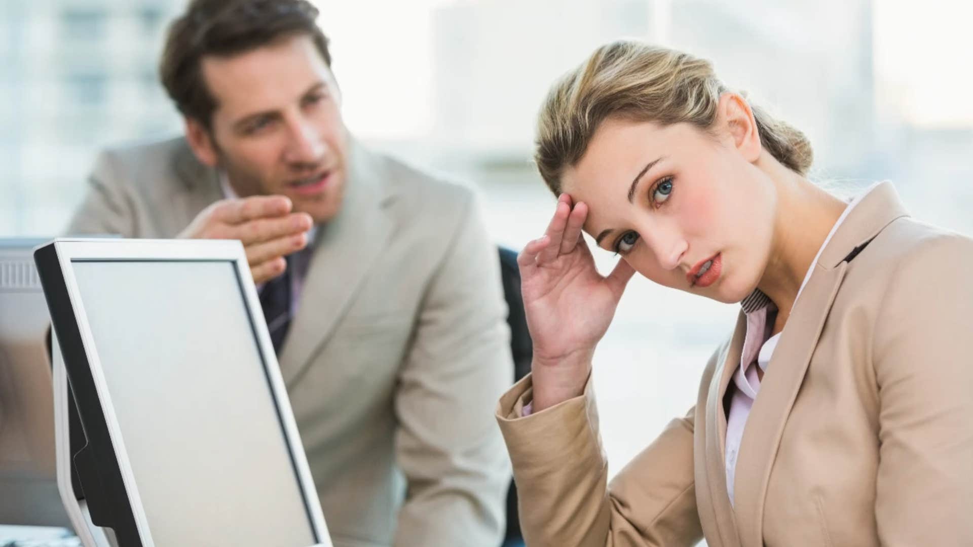 Woman who was the child of divorced parents looks away from an aggressive coworker 