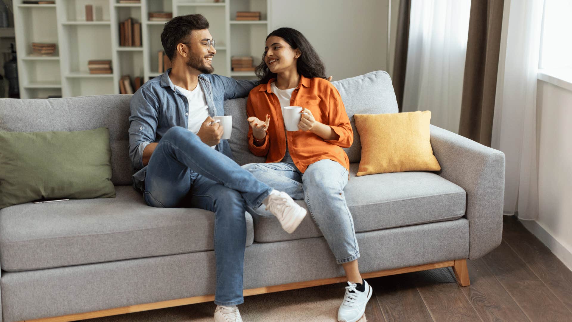 Young couple who were soft parented talking happily on a couch