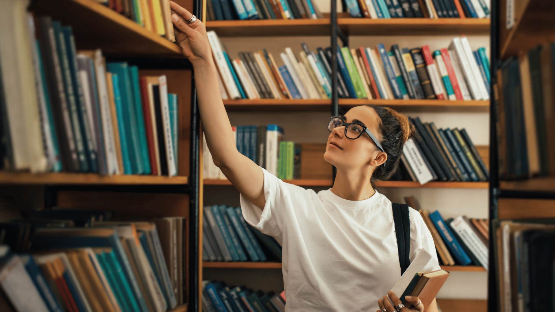 Young woman at the library who was soft parented choosing a book