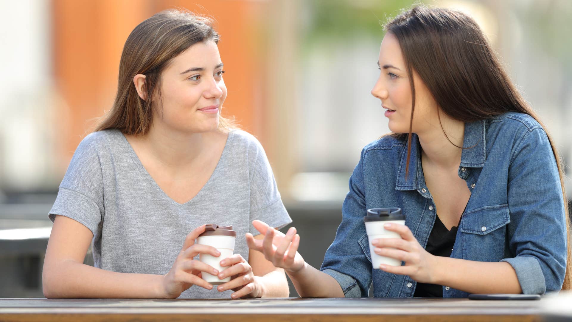 woman in denim shirt asking woman in gray shirt what she's most looking forward to