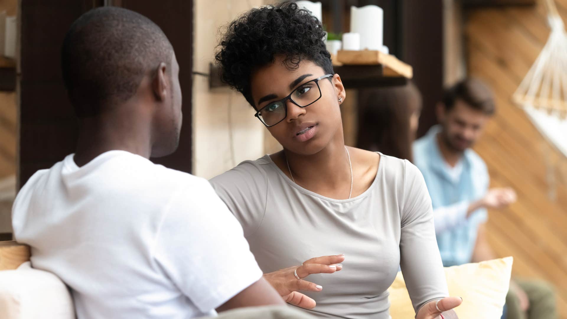 woman in gray shirt asking is this something casual while talking to man in white shirt and sitting