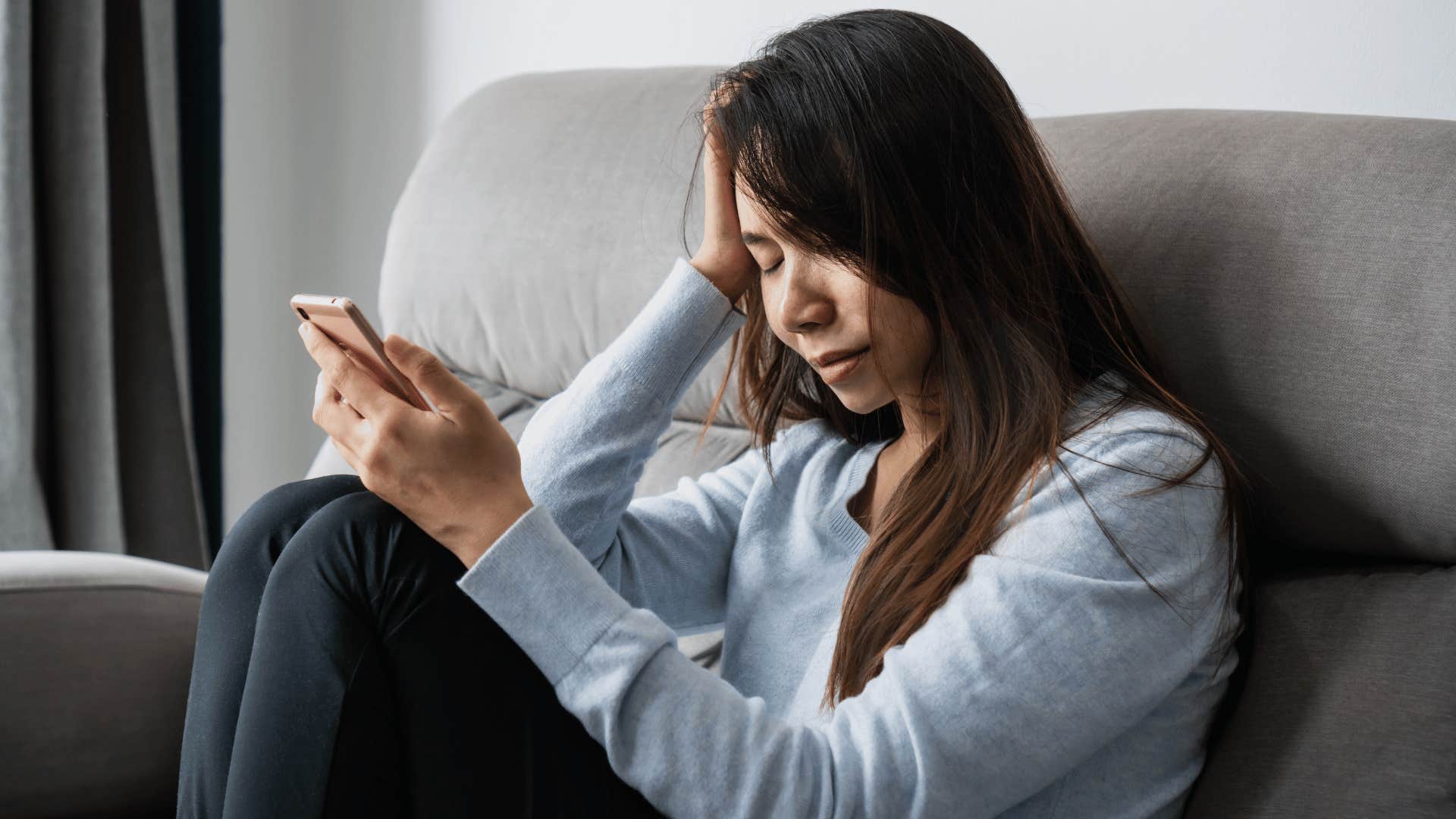 woman looking at phone after falling out with her friends