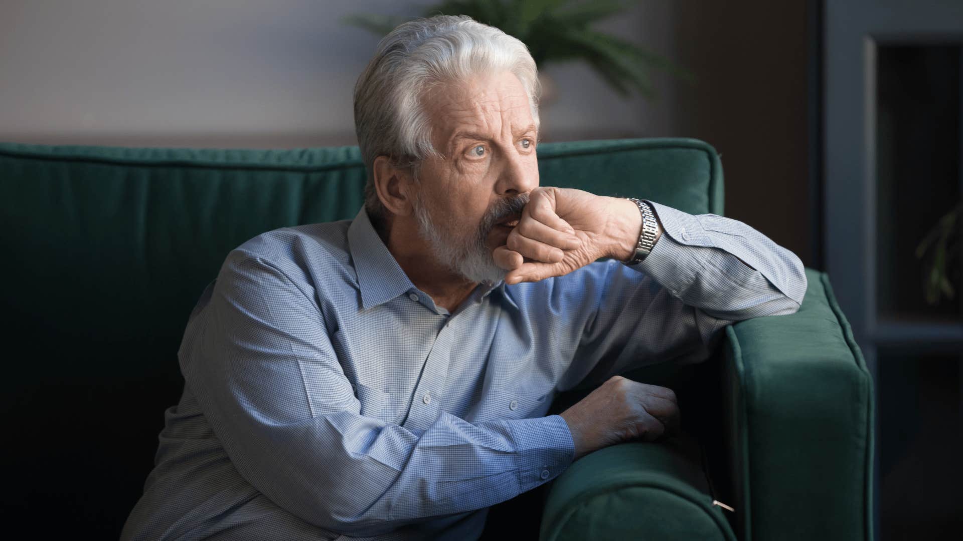 Alienated grandfather sits alone and looks out the window