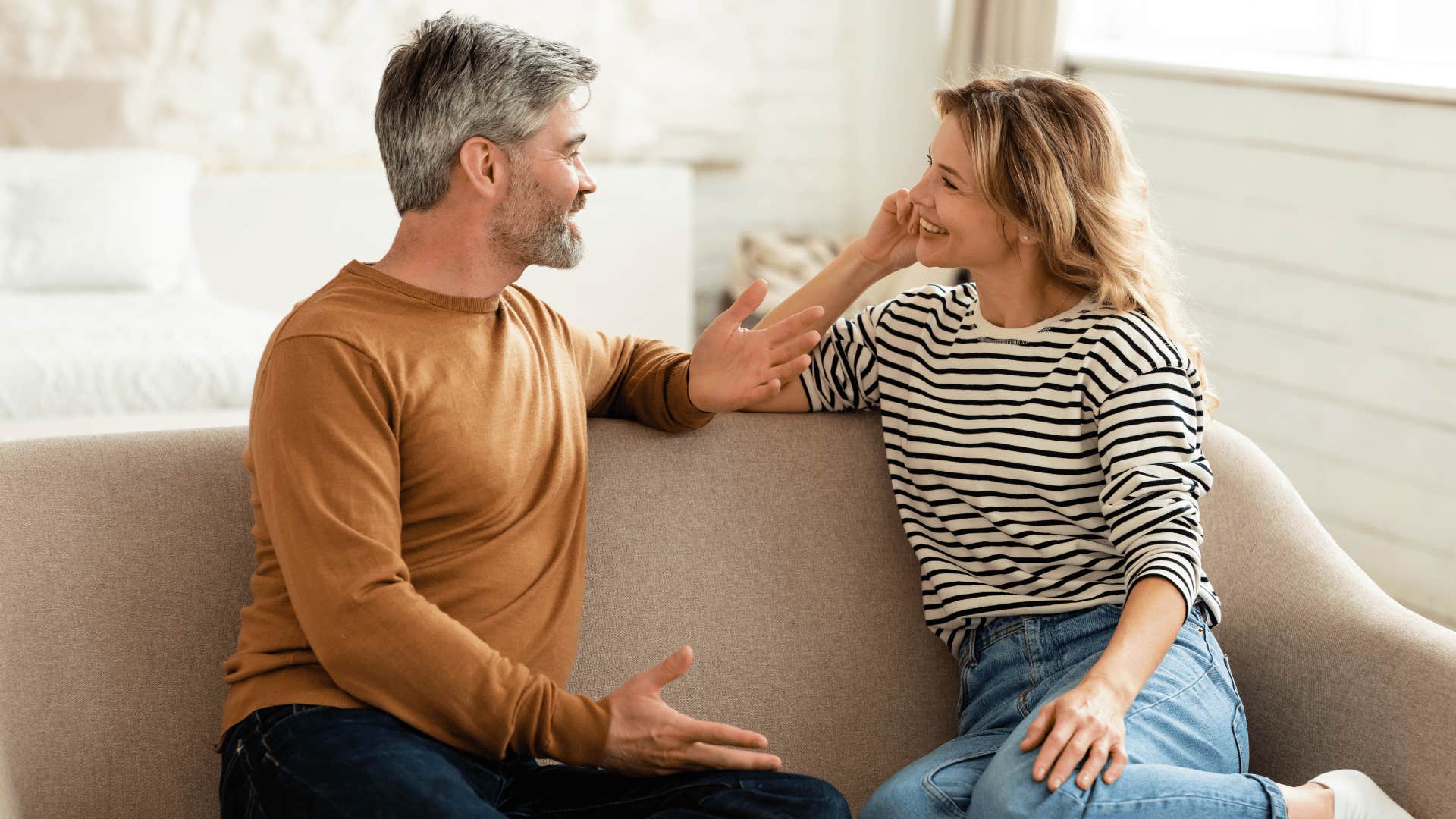 New grandparents talking happily on the couch 