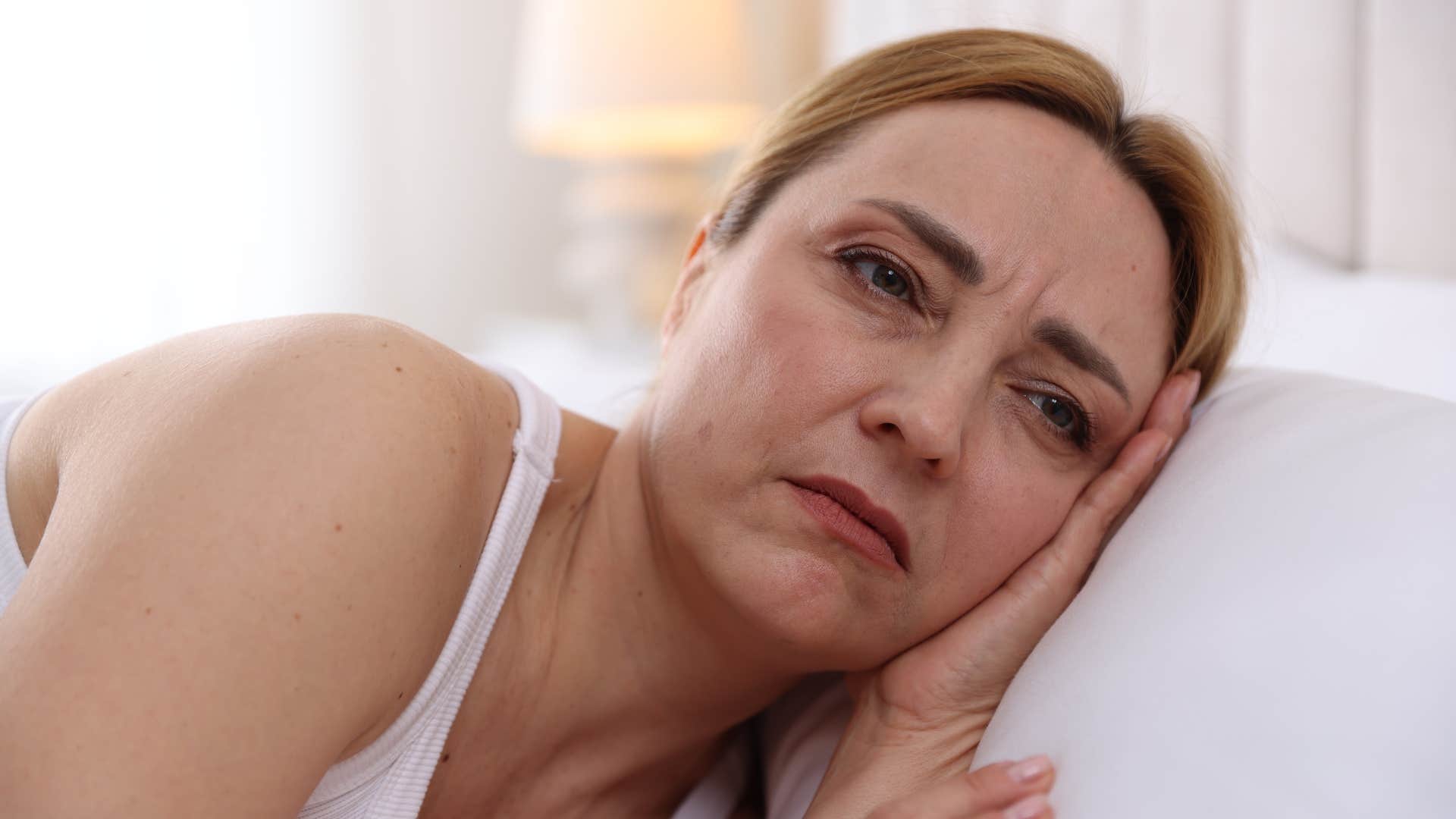sad woman in bed having difficulty trusting others intentions