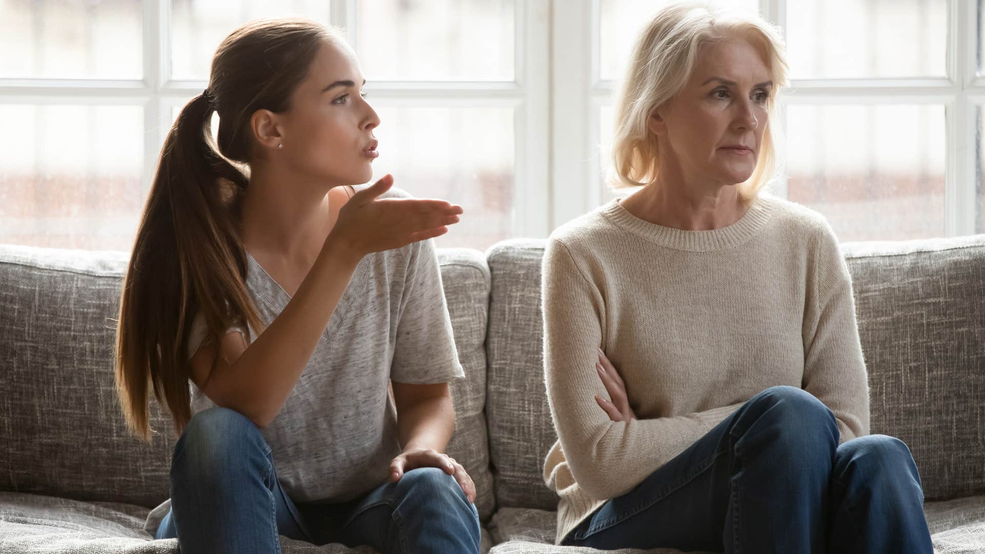 Adult Gen Z daughter speaking angrily to her Gen X mom on a couch