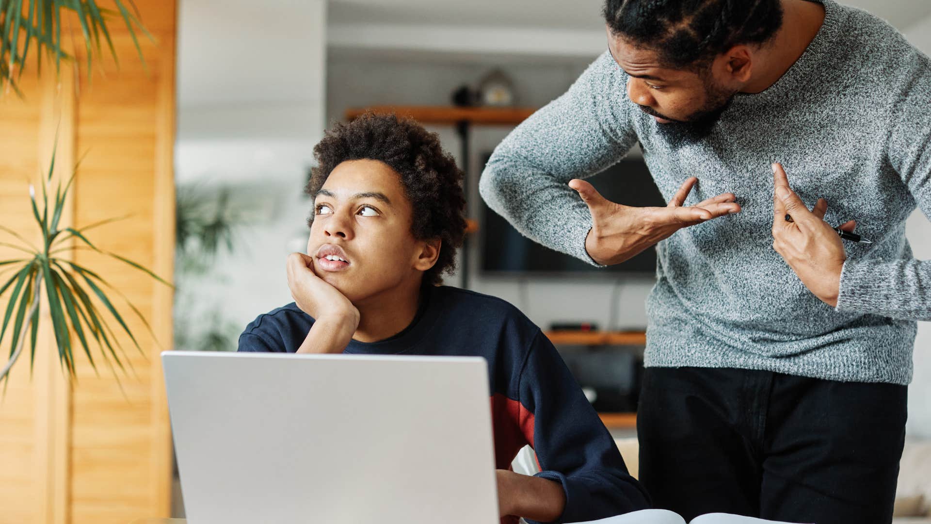 Nosy Gen X dad violating his teen son's boundaries reading his computer over his shoulder 