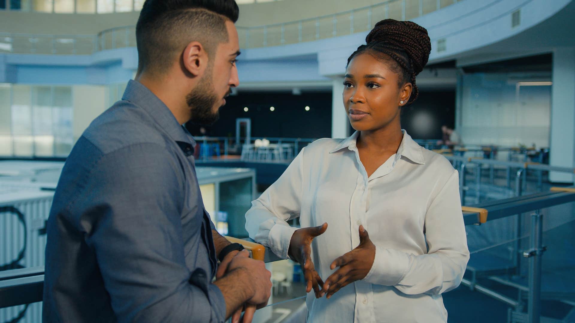 man in blue asking woman Can you explain that one more time so I'm clear