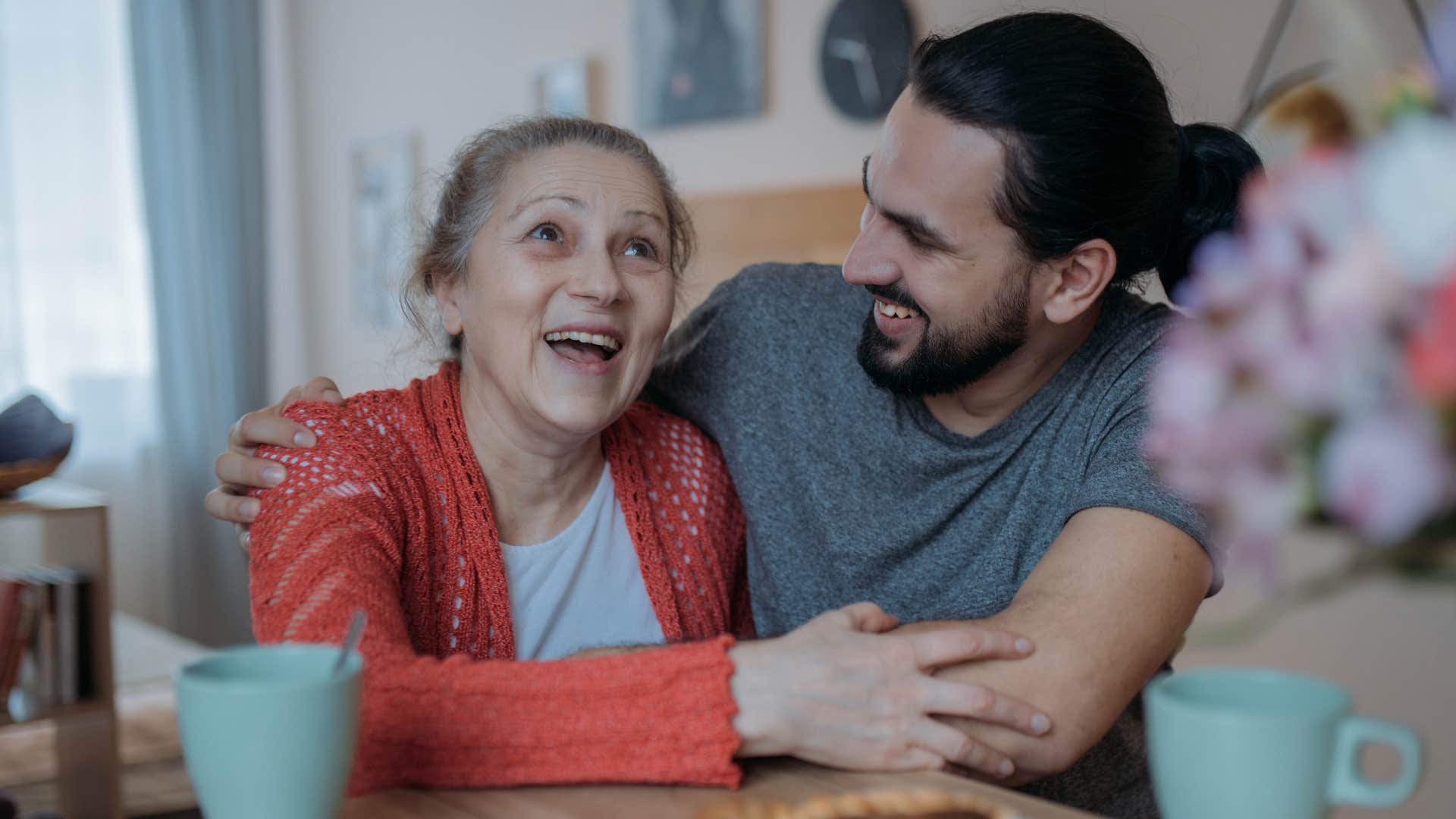 Older woman hugging her adult son joyfully 