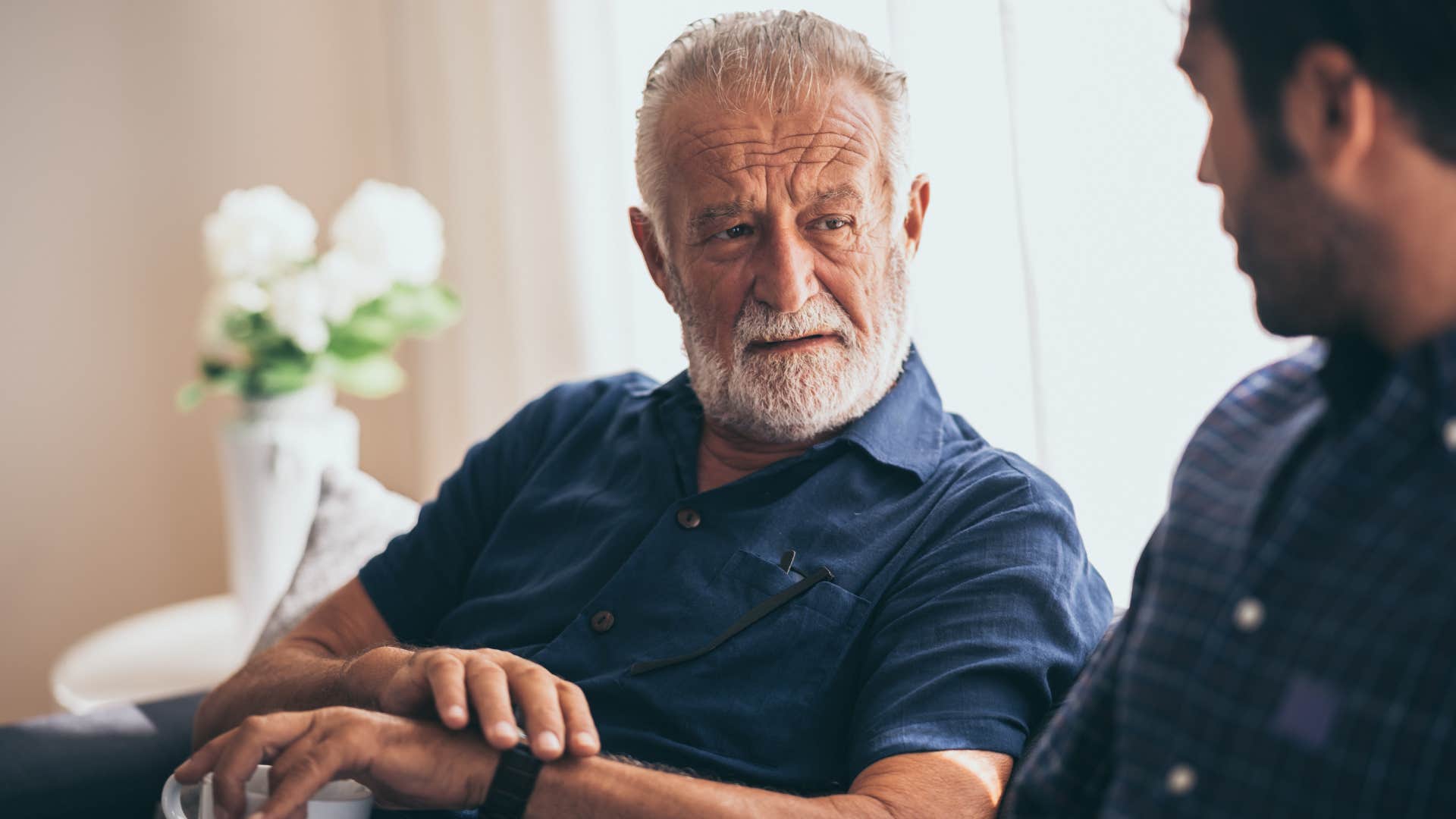 Older toxic father looking judgmentally at his son 