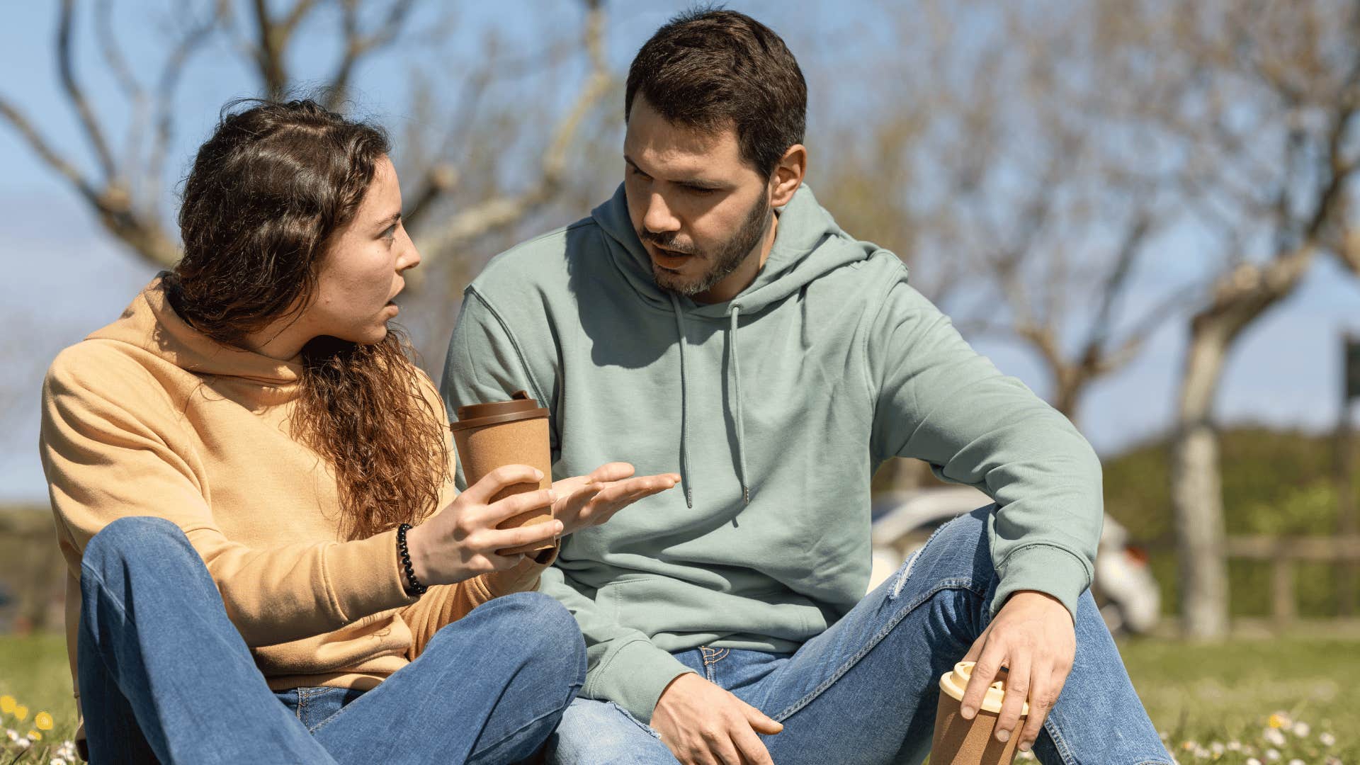 Controlling man manipulating a woman verbally while sitting outdoors 