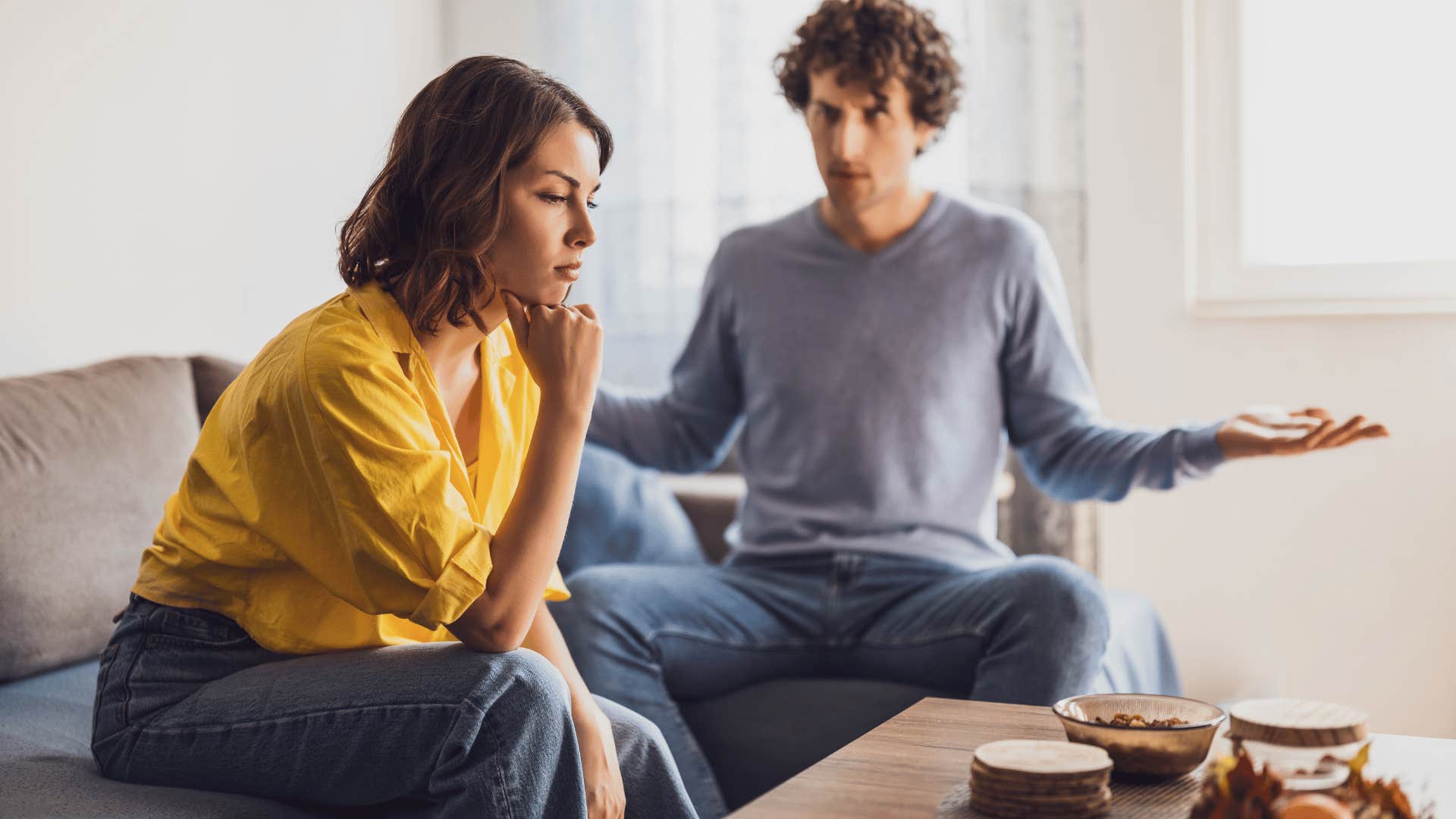 Controlling man looking shocked at a sad women who loves him