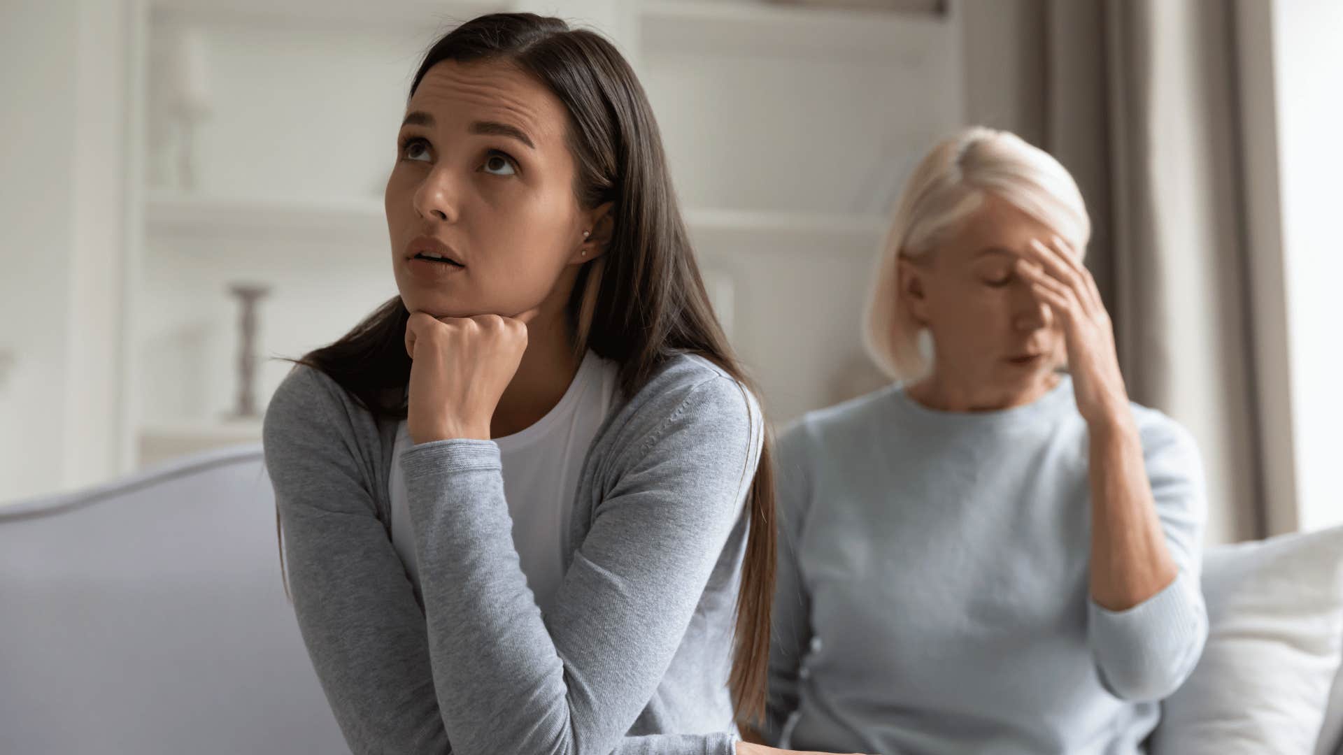 Young adult daughter upset with her older mom who is looking annoyed 