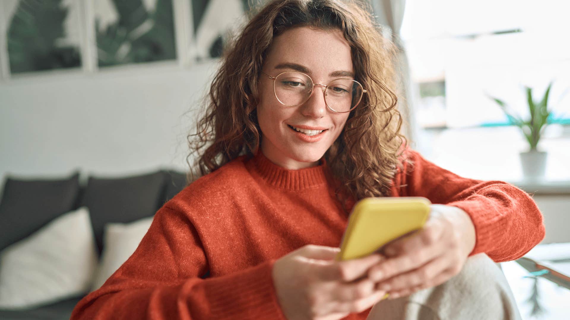 Young woman grasps conversation dynamics others miss as she's texting on her phone