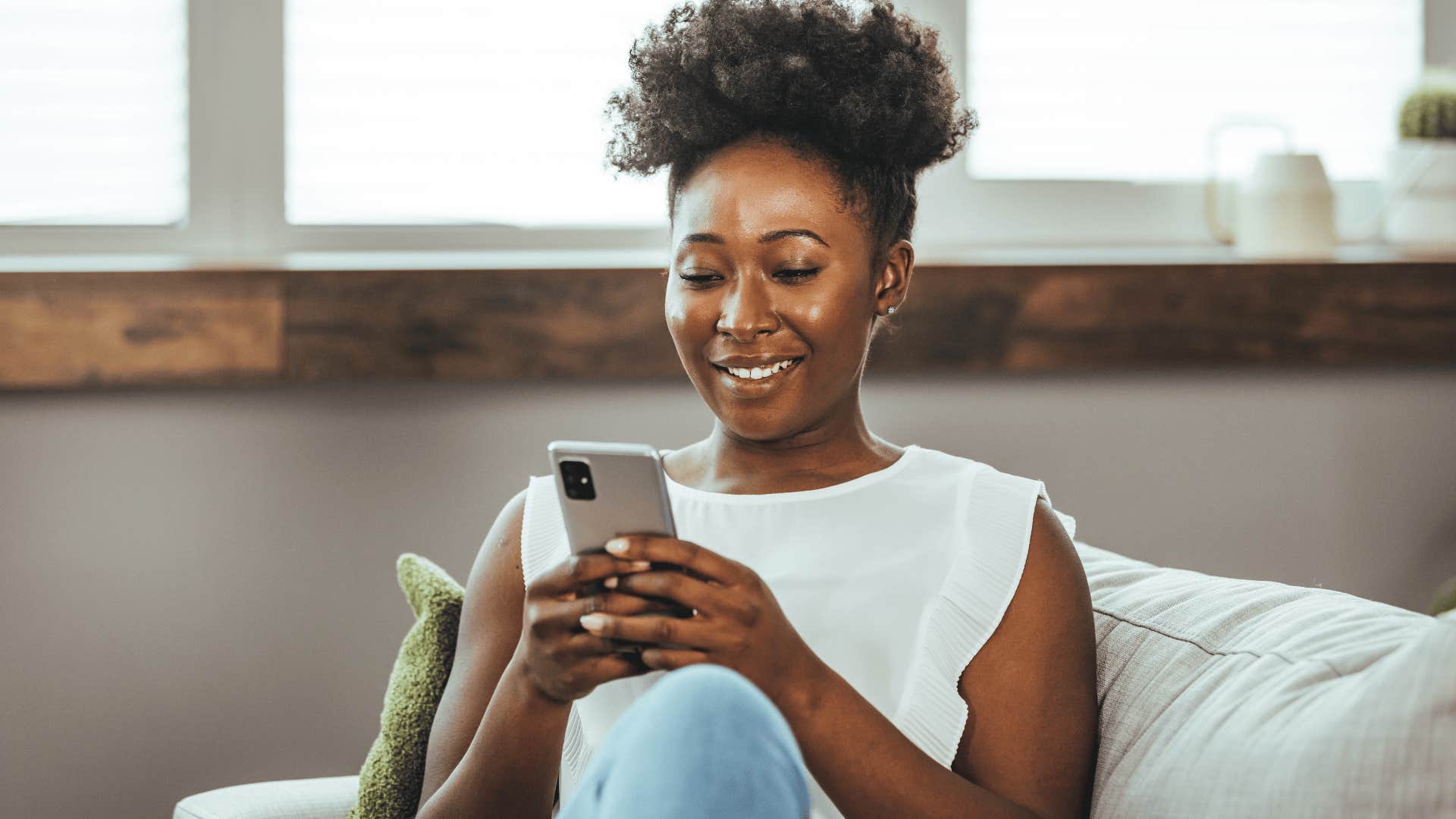 Woman resists peer pressure while texting on her couch