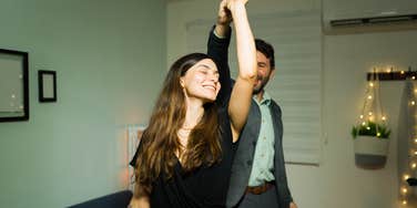 2 Signs You're In A Couple Bubble — And It's Saving Your Marriage Beautiful young woman enjoying a slow dance with her husband in their living room home