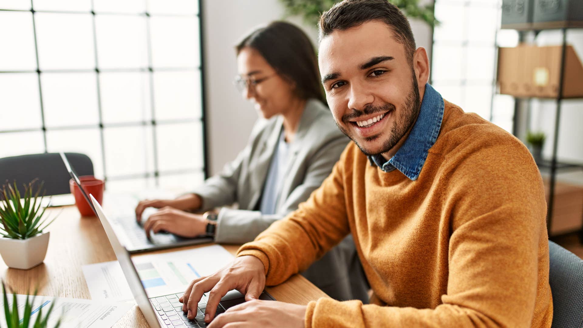 smiling man thinking of the people he's helping at work