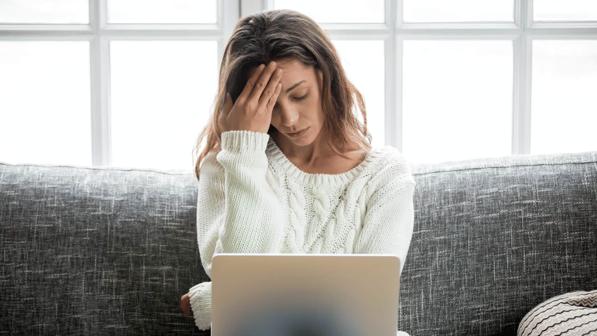 fearful woman on laptop trying to learn about financial literacy