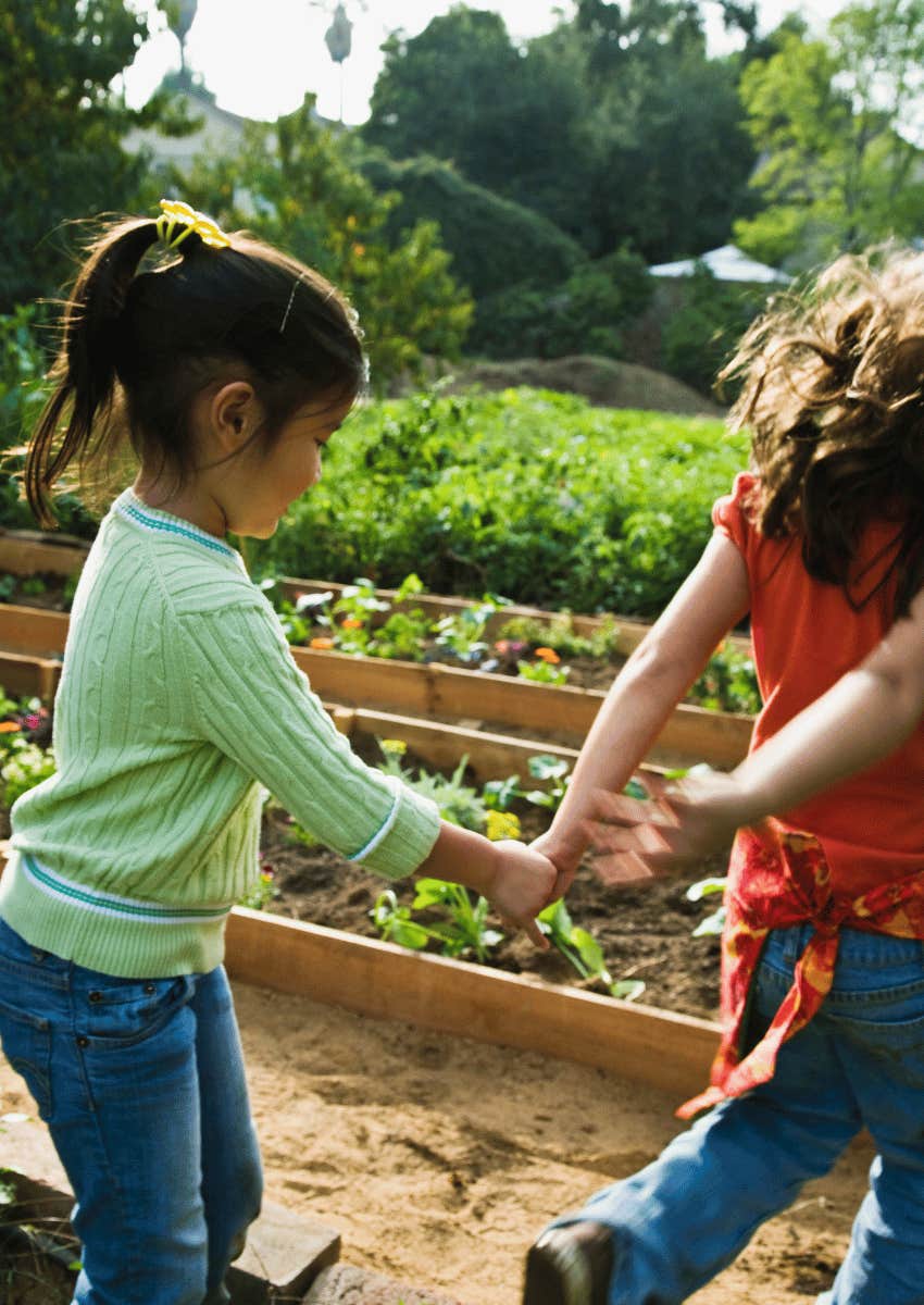 two young girls playing in garden together