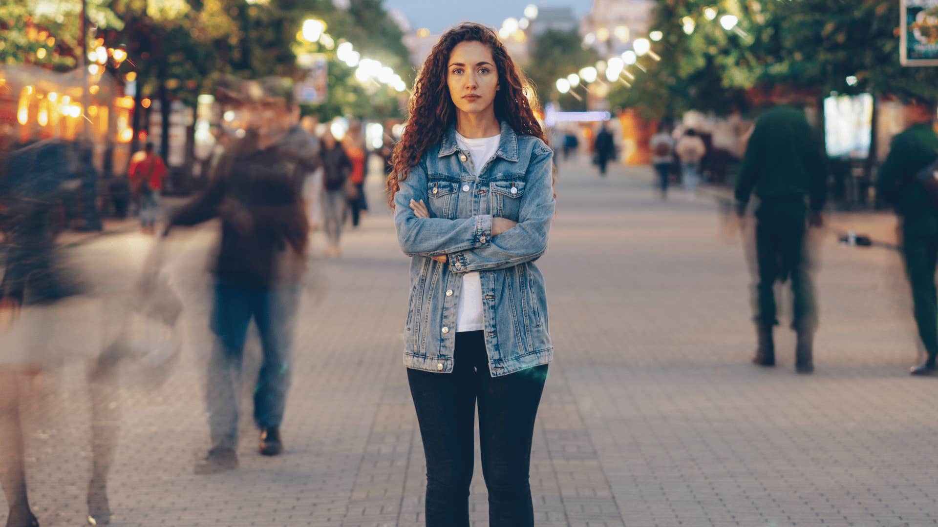 Woman who grew up with lots of money standing alone on a busy street
