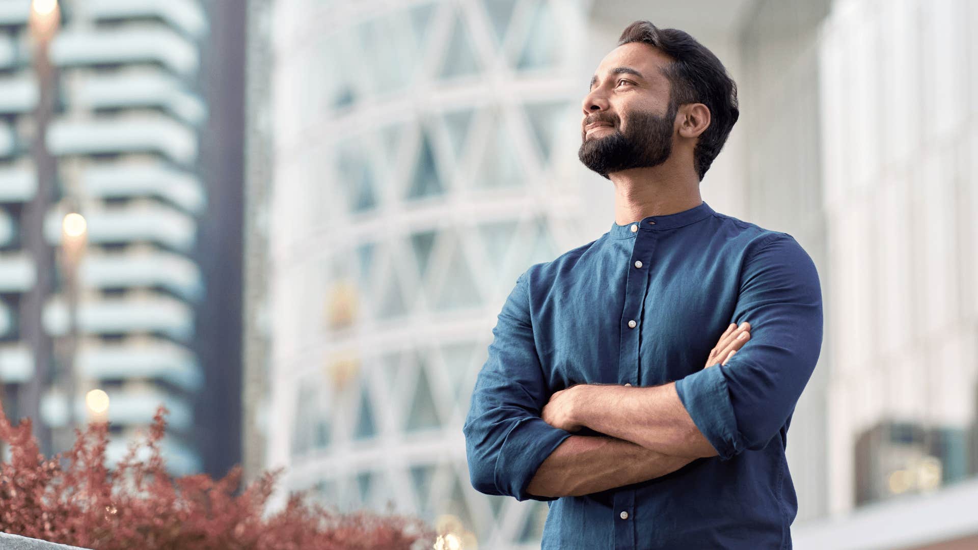 Man who grew up with lots of money stands confidently in a city 