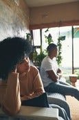 Woman looking overwhelmed and disconnected, symbolizing people-pleasing and losing herself in relationships without clear boundaries