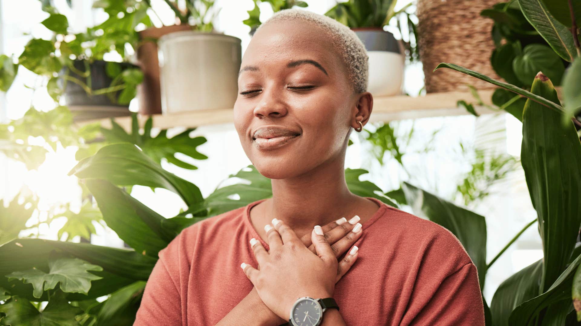 Woman whose parents did an exceptional job peacefully closes her eyes with hands on her chest